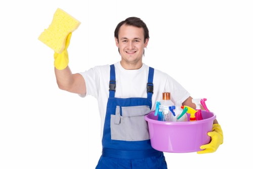 Cleaner carrying out detailed deep cleaning in a local home kitchen
